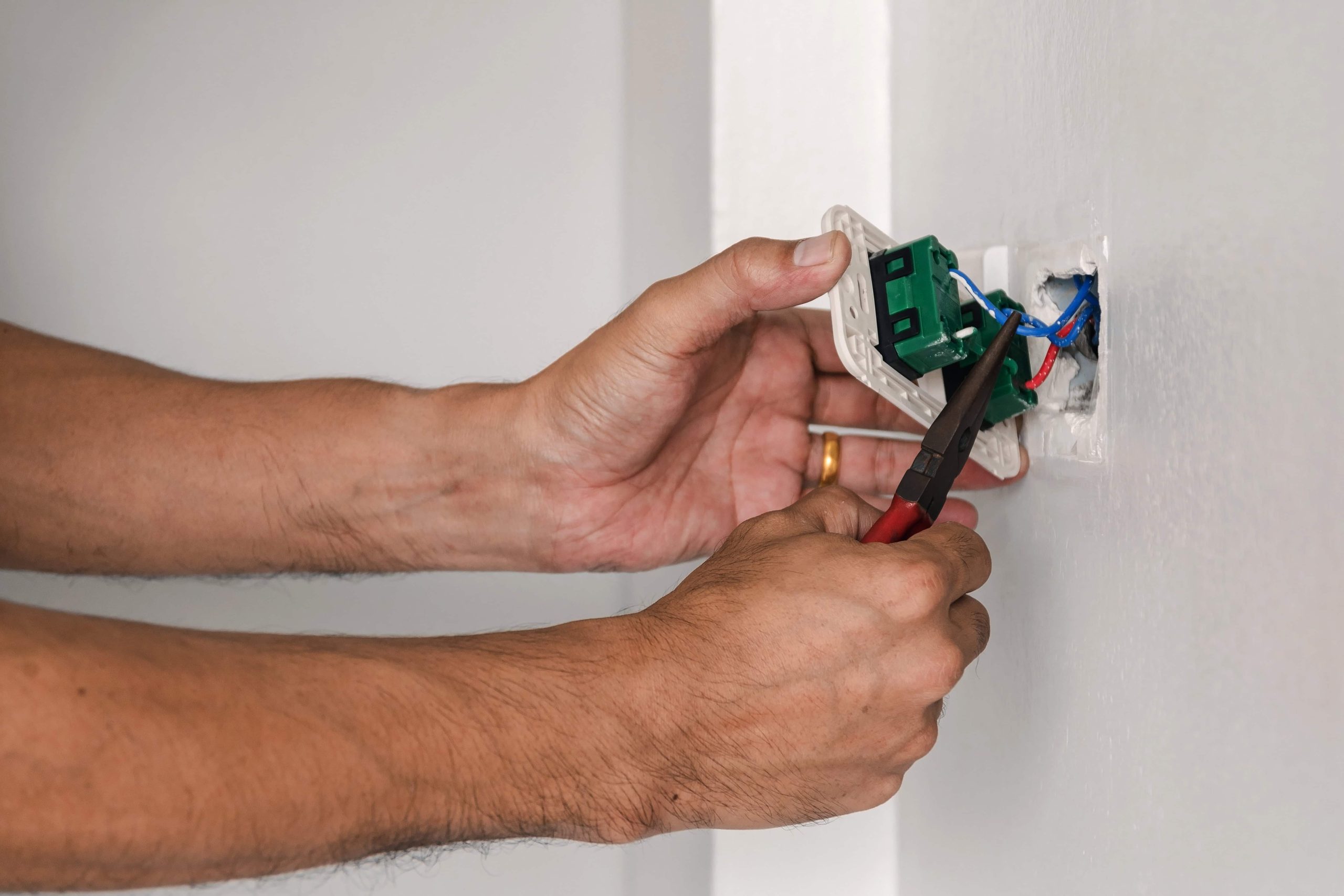 technician-is-using-pliers-install-power-plug-wall-scaled